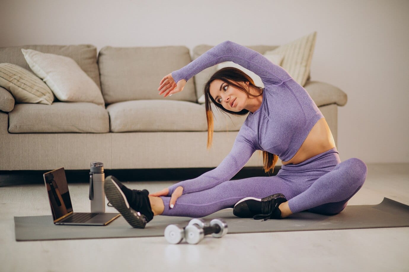 person in purple workout attire stretches