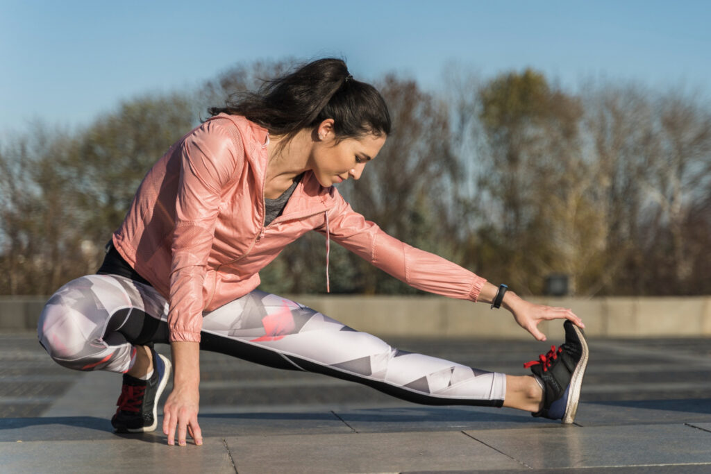 woman stretches her leg forward on a sunny day