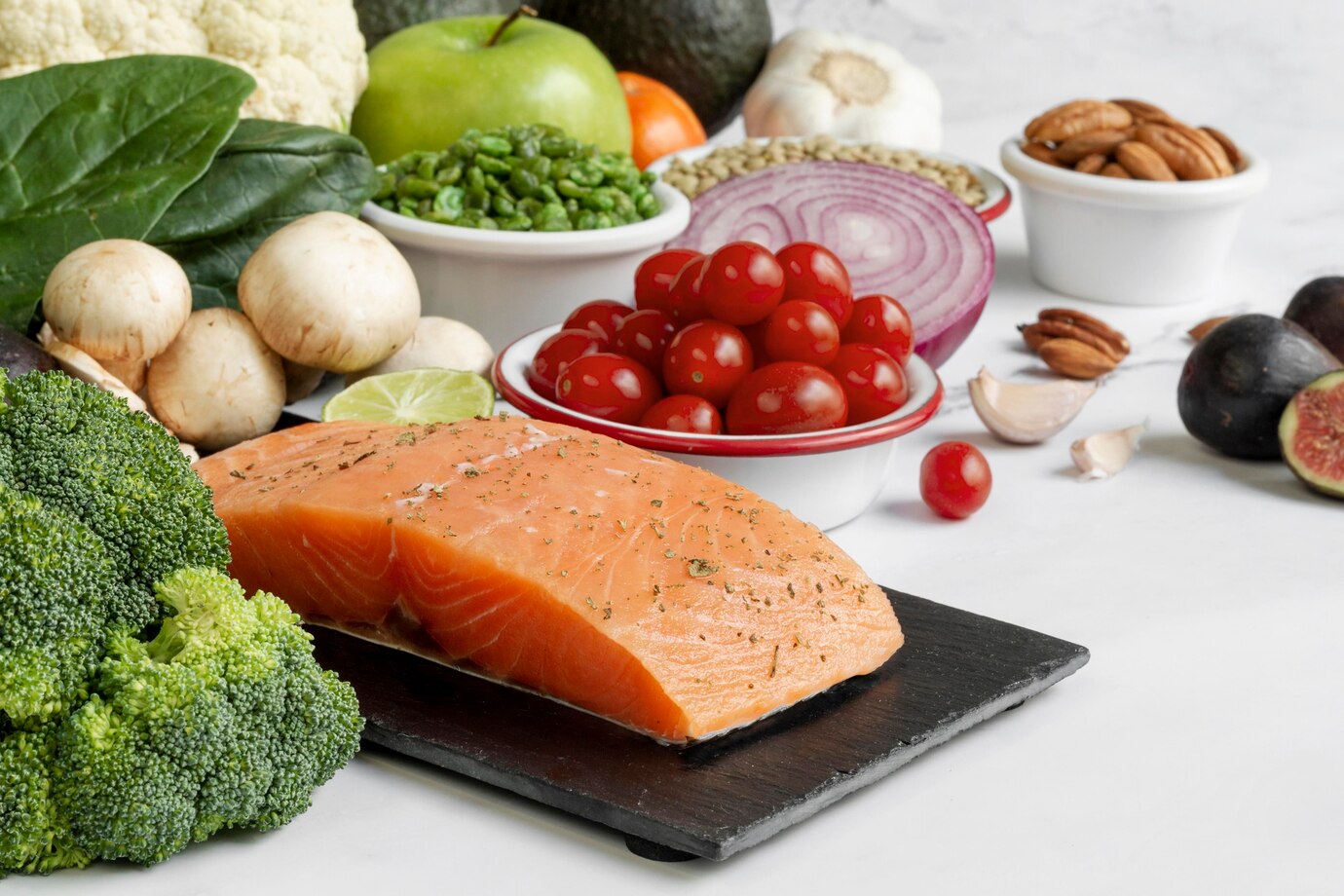 variety of fresh, healthy foods including a large piece of seasoned salmon