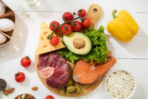 fresh, healthy foods spread on a wooden table, including assorted vegetables
