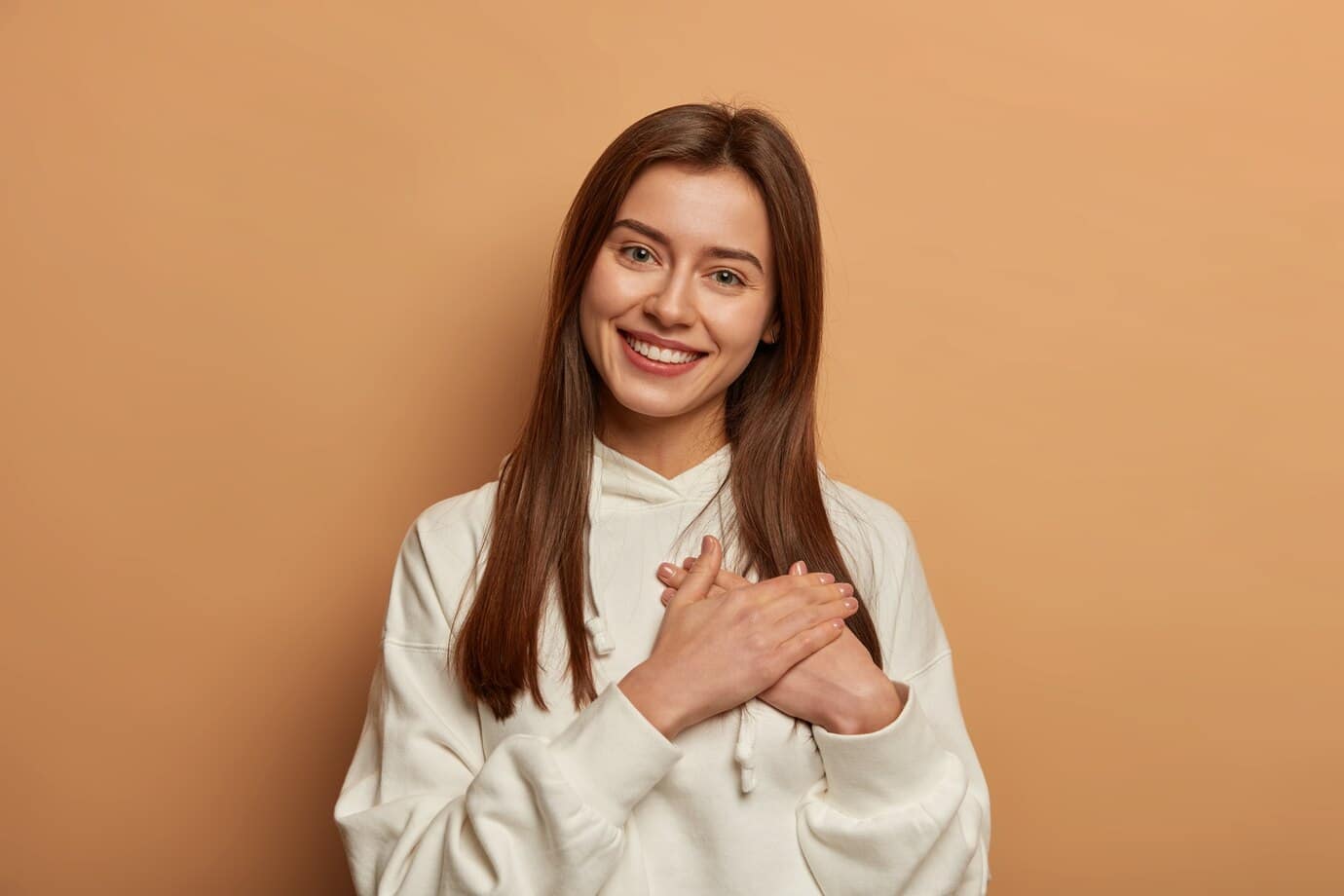 young person hands clasped at their chest