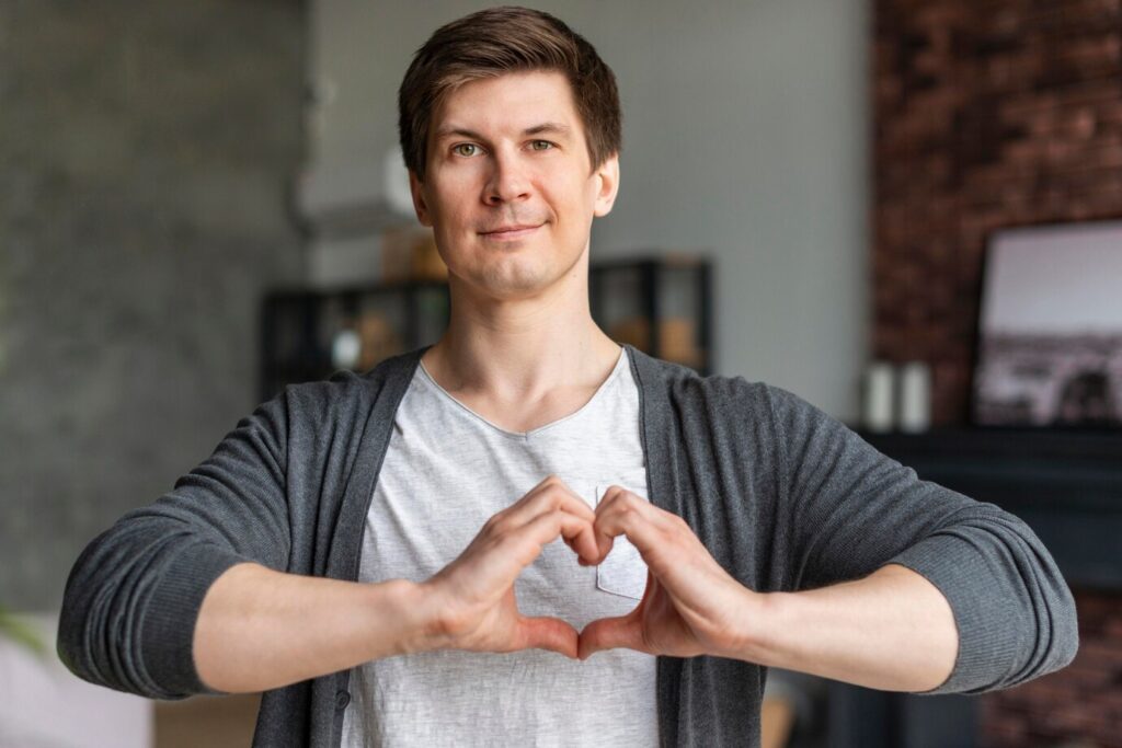person creates a heart shape with their hands